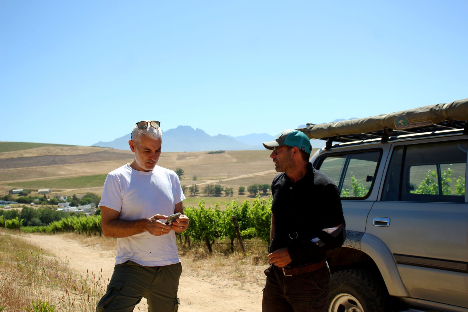 Michael Salverda on the phone with grower Jozua among the vines on Polkadraai, Stellenbosch